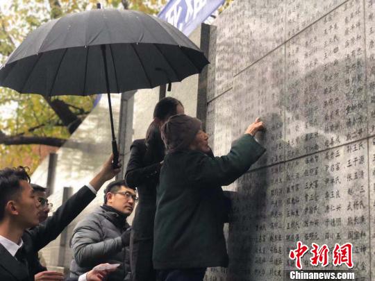 夏淑琴老人用手撫摸著親人的名字?！≈鞎苑f 攝