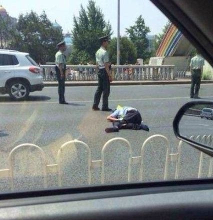 交警被撞出大概10米左右，趴在地上一動(dòng)不動(dòng)。