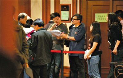 12日，北京麗都飯店，馬航工作人員叫乘客家屬進(jìn)屋領(lǐng)取慰問(wèn)金。目前，馬航兩次向乘客家屬發(fā)放慰問(wèn)金，但未啟動(dòng)賠償。新京報(bào)記者